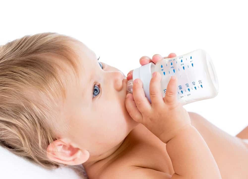 a baby drinking milk from a bottle