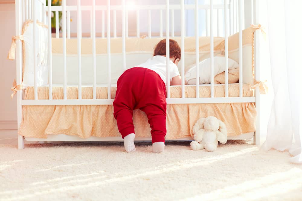 a toddler climbing out of her crib