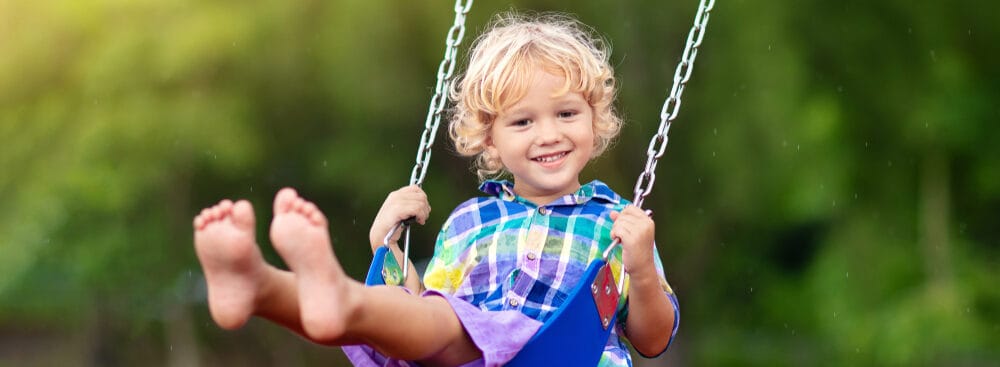 child playing on outdoor playground e1621237384278