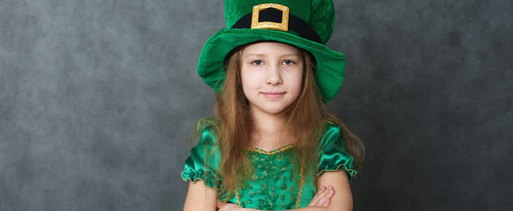 girl in green emerald costume and leprechaun top hat with golden buckle e1618928082373