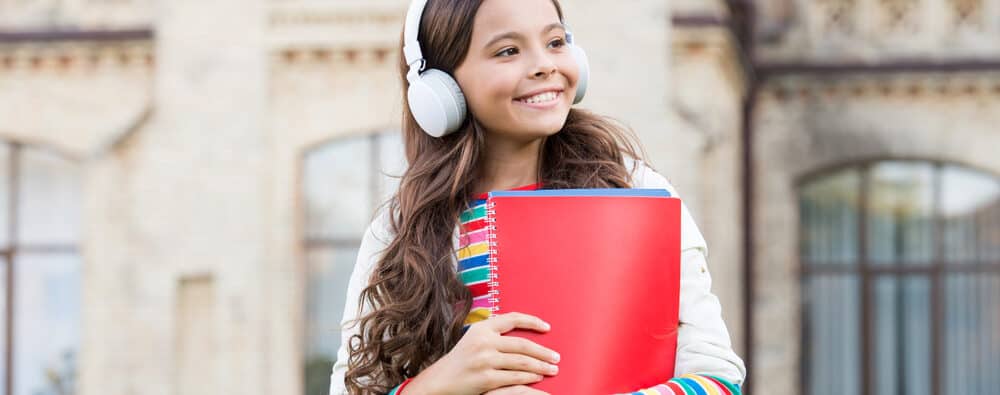 happy child listening to english audio course e1619245448350